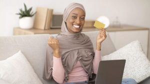 happy-black-woman-in-hijab-holding-credit-card